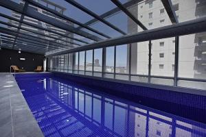 a large swimming pool in a building with windows at A Stylish 2BR Apt Next to Crown with FREE Parking in Melbourne