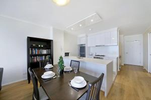 een eetkamer en een keuken met een tafel en stoelen bij A Stylish 2BR Apt Next to Crown with FREE Parking in Melbourne