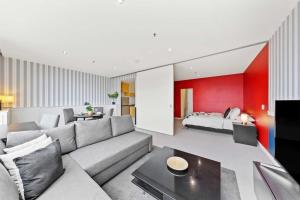 a living room with a couch and a bed at Comfy CBD Apt in QV with City Views FREE Parking in Melbourne