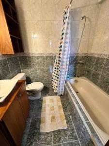 a bathroom with a toilet and a tub and a sink at Casa Comoda Centrica con Garage in Puyo +19 photos