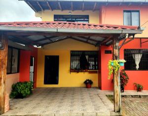 a house with a yellow and red wall at Casa Comoda Centrica con Garage in Puyo