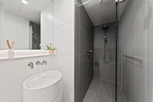 a bathroom with a shower and a toilet and a sink at A Chic 2BR Apt Near Melbourne CBD w FREE Parking in Melbourne