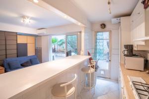een keuken met witte werkbladen en een groot raam bij Beauvallon furnished flat in Cannes