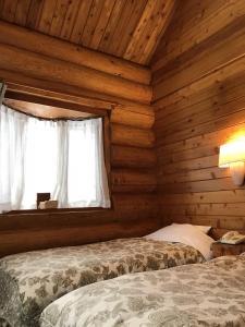 Un pat sau paturi într-o cameră la log Hotel kamloops