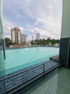 uma grande piscina com água azul num edifício em Comfy 2BR TriTower Suite next to JB CIQ, JBCC & Capri em Johor Bahru