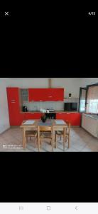 een keuken met een tafel en stoelen en rode kasten bij Da Leo in Marina di Montenero