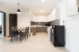 a kitchen with a table and a black refrigerator at Modern, High Floor Suasana Suites 05 in JB in Johor Bahru