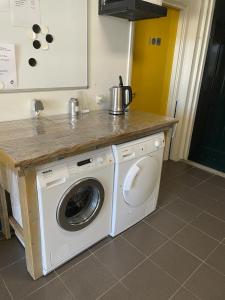 Una lavadora y secadora bajo una barra en la cocina en Pieterwagen, en Sleen