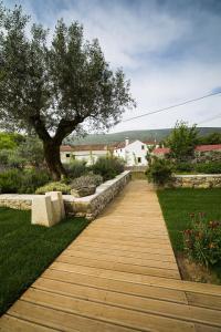 a wooden walkway in a garden with a tree at Casa dos Aromas - Nature Tourism in Alvados