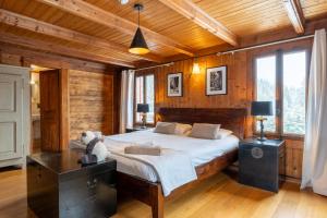 a bedroom with a large bed in a room with wooden walls at Chalet-Sixtine A large family chalet of 600m2 near La Clusaz in Saint-Jean-de-Sixt