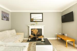 a living room with a white couch and a fireplace at Modern Elegant Central Apt with Parking in Dublin