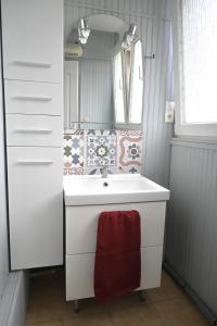 Chez Maïse - CR CONCIERGERIE في دونكيرك: حمام مع حوض أبيض ومرآة