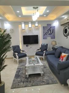 a living room with blue couches and a tv at مصر المهندسين عبد العزيز جاويش in Cairo