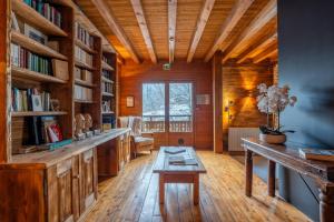 a library with a table and bookshelves at Chalet-Sixtine A large family chalet of 600m2 near La Clusaz in Saint-Jean-de-Sixt