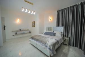 a bedroom with a bed and a large window at El AMO LAKEVIEW VILLA in Entebbe