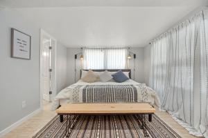 a white bedroom with a bed and a window at Downtown Studio 1 at Beer Ranch Project Inn in Wimberley