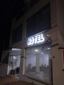 a hotel sign on the side of a building at night at Hotel Flat Almaru - Marília in Marília