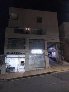 un edificio de hotel por la noche con un cartel en Hotel Flat Almaru - Marília, en Marília