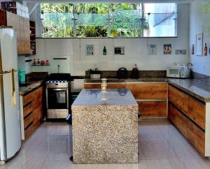 a large kitchen with a island in the middle at Pousada MarÍsis Barra da Tijuca in Rio de Janeiro