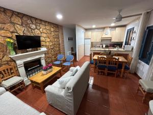 - un salon avec un canapé et un mur en pierre dans l'établissement Casa Rural La Aldea, à San Clemente