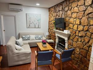 - un salon avec un mur en pierre dans l'établissement Casa Rural La Aldea, à San Clemente