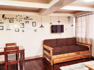 a room with a couch and a tv on a wall at City Oasis: Steps Away from Urban Buzz in Baguio