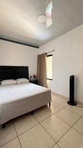 a bedroom with a bed and a window and a fan at Amplio y moderno apartamento de 1 habitación in Tegucigalpa