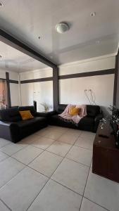 a living room with two black couches and a table at Amplio y moderno apartamento de 1 habitación in Tegucigalpa