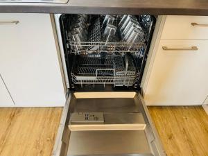 an open dishwasher with a box in it in a kitchen at LIGHTPLACE - Moderne Apartments in Braunschweig - Balkon - Netflix - Am Kanal in Braunschweig