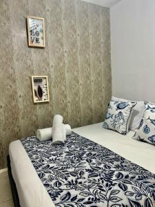 Schlafzimmer mit einem Bett mit blauer und weißer Bettwäsche und Kissen in der Unterkunft Hotel Casa Centro Historico De Cartagena Colombia in Cartagena de Indias