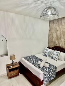ein Schlafzimmer mit einem Bett und einem Tisch mit einer Lampe in der Unterkunft Hotel Casa Centro Historico De Cartagena Colombia in Cartagena de Indias