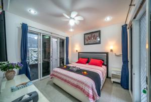 a bedroom with a bed with red pillows and a window at Modern villa with private pool , full kitchen and parking in Legian +86 photos