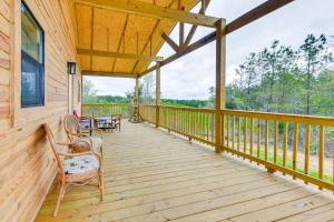 a large wooden porch with chairs and a table at Abbeville Cabin on 450 Acres Near Lake Eufaula! in Abbeville