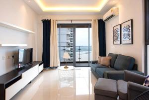 een woonkamer met een bank en een televisie bij Comfy 3BR Apt in Danga Bay FREE Parking Sea View in Johor Bahru
