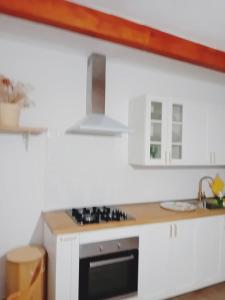 cocina con armarios blancos y fogones en Apartamento Casa Rosabella en Caleta de Sebo