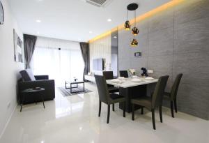 a dining room with a black table and chairs at A Stylish High-Floor 2BR Suasana Suites Views in Johor Bahru