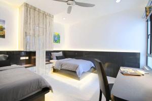 ein Schlafzimmer mit einem Bett, einem Schreibtisch und einem Tisch in der Unterkunft A Stylish High-Floor 2BR Suasana Suites Views in Johor Bahru + 26 Fotos