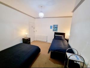 a bedroom with two beds and a table and a lamp at Plymouth Airbnb in Plymouth