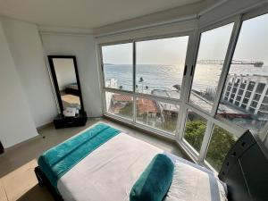 a bedroom with a bed and a view of the ocean at U-GO Refugio Tropical en El Laguito - Elegancia y Descanso in Cartagena de Indias