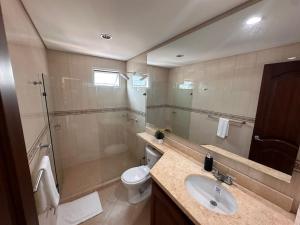 a bathroom with a sink and a toilet and a mirror at U-GO Refugio Tropical en El Laguito - Elegancia y Descanso in Cartagena de Indias