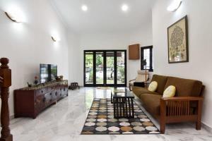 een woonkamer met een bank en een tafel bij A Stylish & Spacious 4BR Home for Family Getaways in Kuala Lumpur