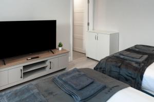 a living room with a flat screen tv and a bed at Chic 1BR Gem, Croydon Central in Croydon