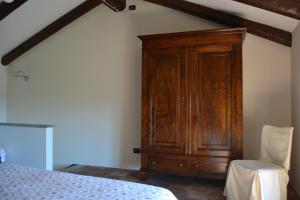 a bedroom with a wooden cabinet next to a bed at Dimora al Castello in Govone