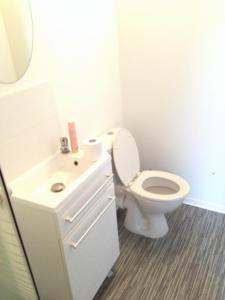 a white bathroom with a toilet and a sink at Spacieuse maison avec chambre et salle de bain privées à 10 min de Lille. in Lille