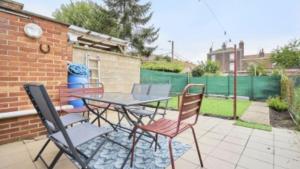 a patio with a table and chairs and a fence at Spacieuse maison avec chambres et salle de bain privées en colocation à 10 min de Lille in Lille