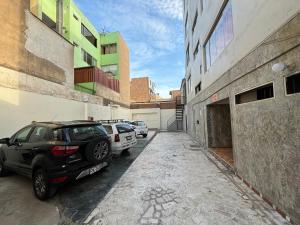 un coche aparcado en un aparcamiento entre dos edificios en Hospedaje San Blas, en Lima