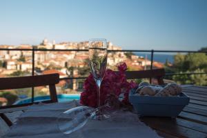 un tavolo con un bicchiere di vino e una ciotola di fiori di Villa Caterina a Imperia