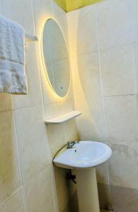 a bathroom with a sink and a mirror at Appartement 2 chambres salon haut standing in Abomey-Calavi