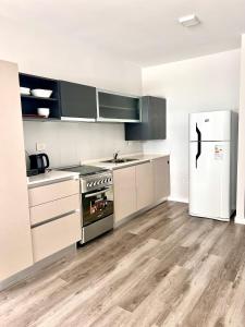 una cocina con estufa y refrigerador en Depto con vistas, en San Nicolás de los Arroyos 3 fotos más
