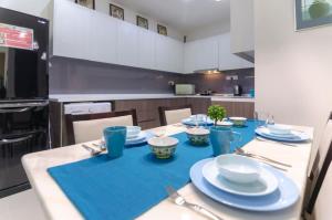 a dining room table with blue dishes on it at A Comfy & Cozy Suasana Suites in Johor Bahru in Johor Bahru